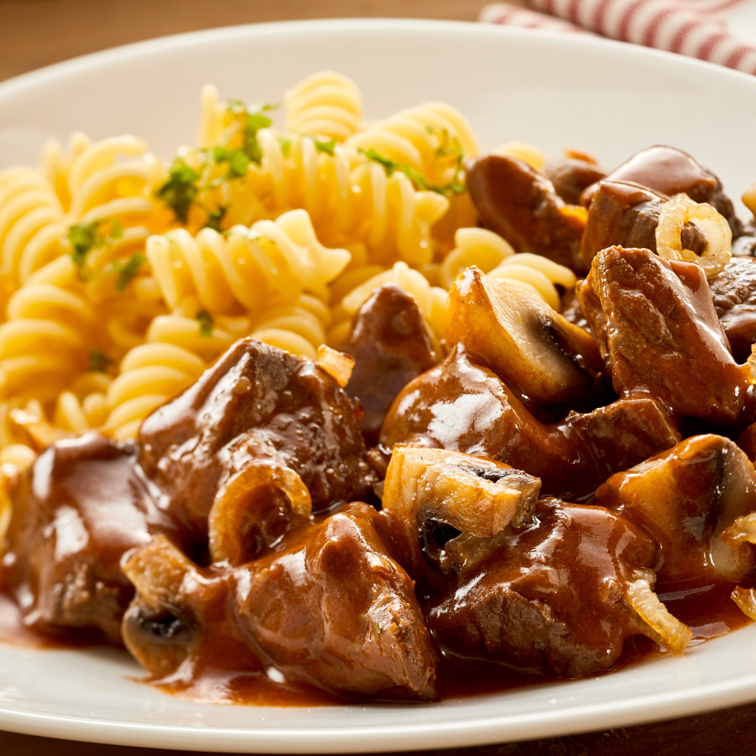 Elevated view of freshly made Hungarian goulash with garnished pasta on plate
